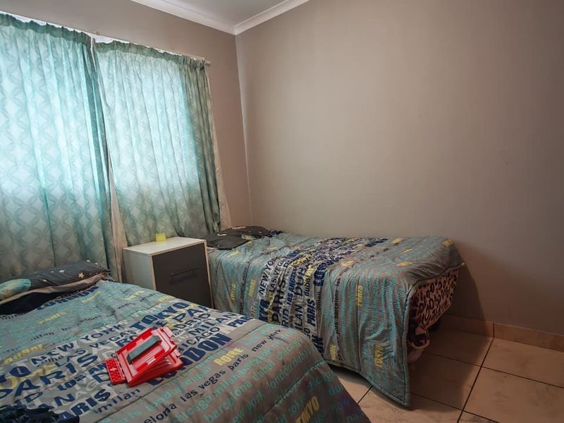 A functional bedroom featuring tiled flooring and a built-in wardrobe, providing essential storage space.