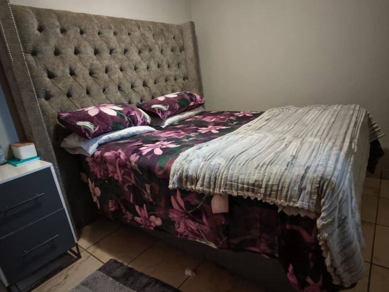 A bedroom featuring tiled flooring and neutral wall finishes, providing a functional space for rest.