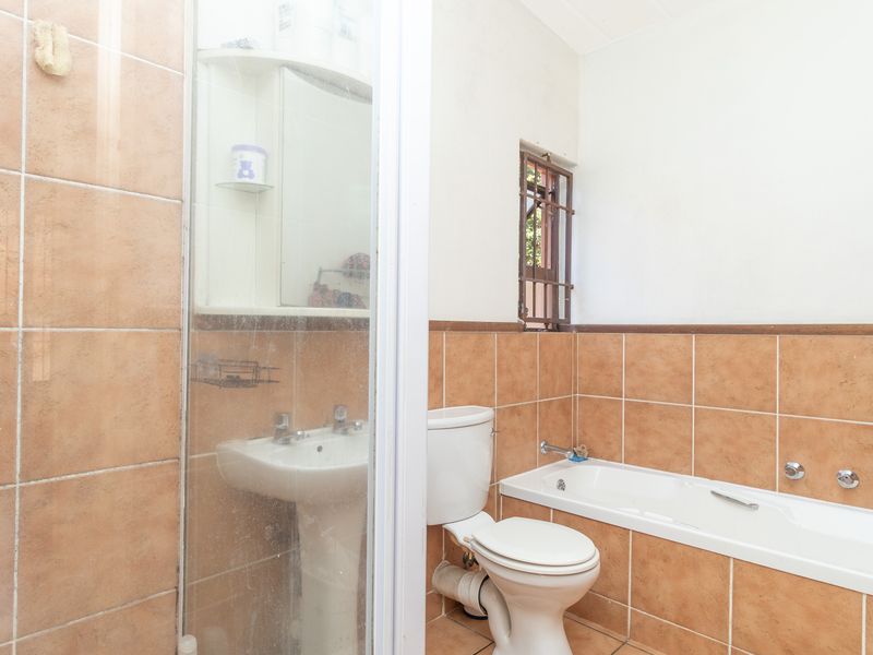 A dated bathroom featuring a pedestal basin, toilet, bathtub, and a separate shower enclosure with tiled finishes throughout.