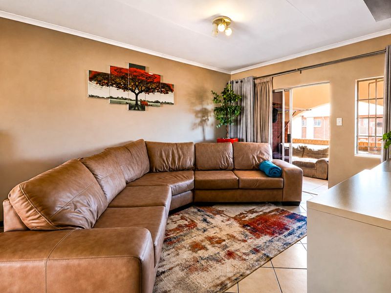 A comfortable living room featuring tiled flooring and a sliding glass door that provides direct access to an outdoor patio area.