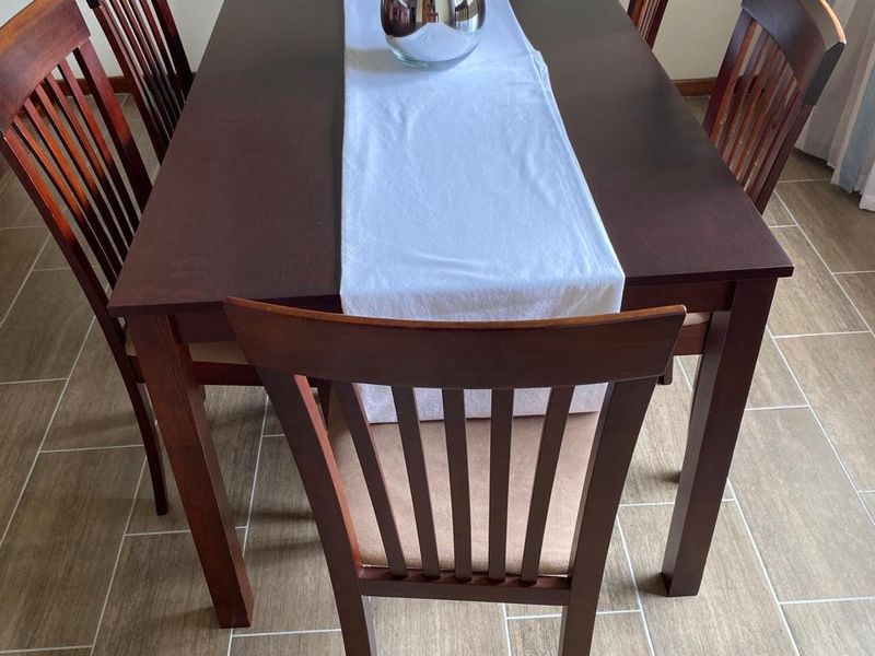 A dining area featuring neutral ceramic tile flooring, providing a clean and functional space for meals.