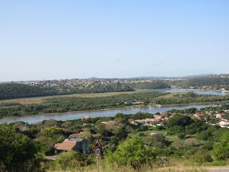 A scenic elevated view overlooking a river, lush green landscape, and surrounding residential neighborhood.