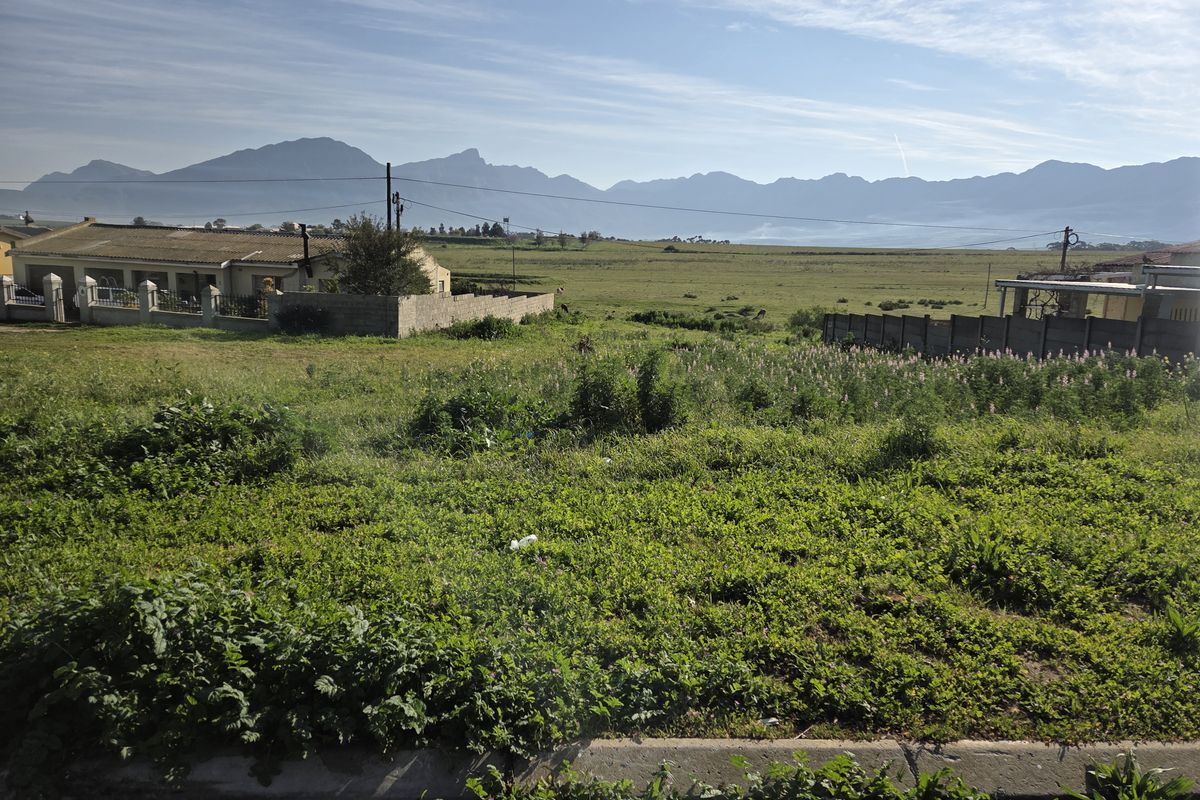 A vacant residential plot featuring expansive mountain views and established boundary walls, offering a scenic outlook in a quiet neighborhood setting.