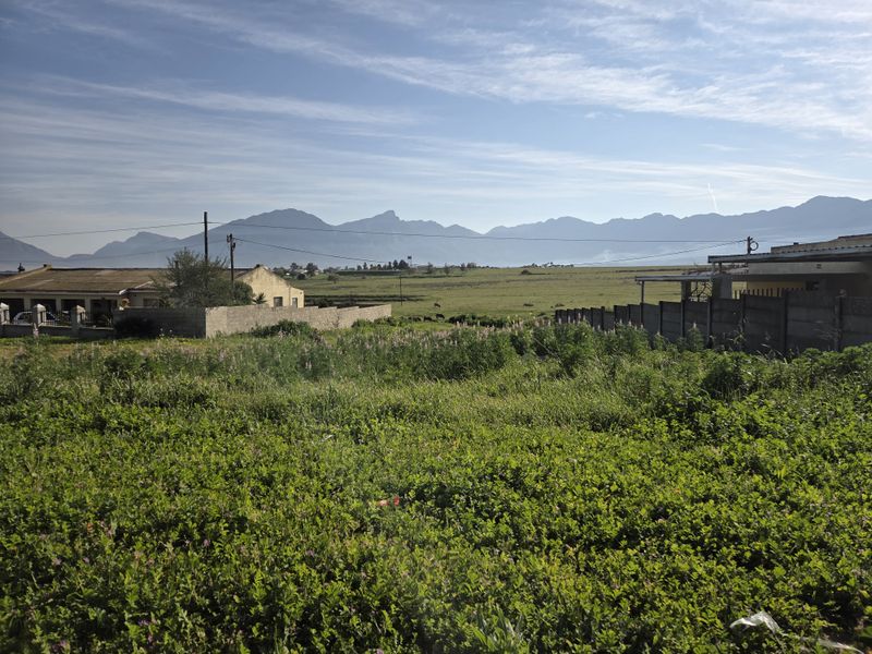 A view of the vacant residential land featuring surrounding boundary walls and scenic mountain vistas in the background.