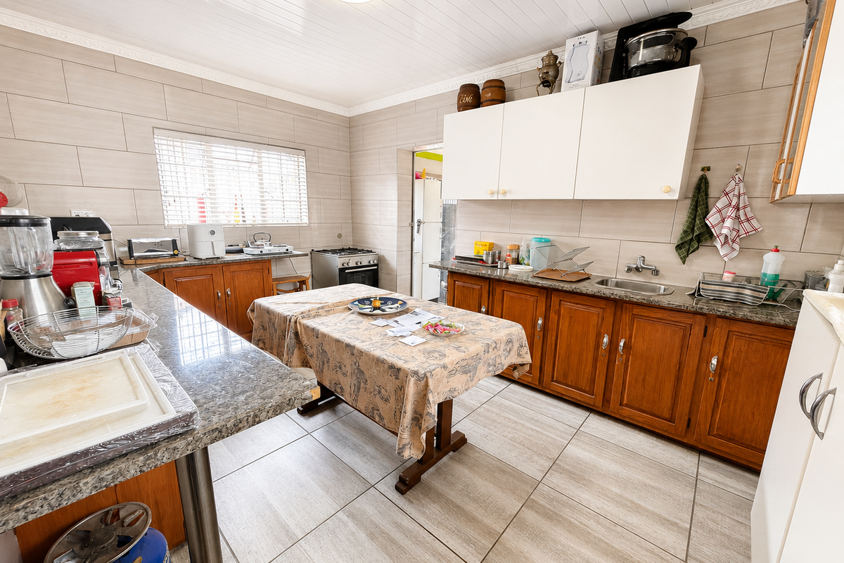 A functional kitchen featuring wooden cabinetry, granite countertops, tiled walls, and a gas stove, offering a practical layout with ample storage space.