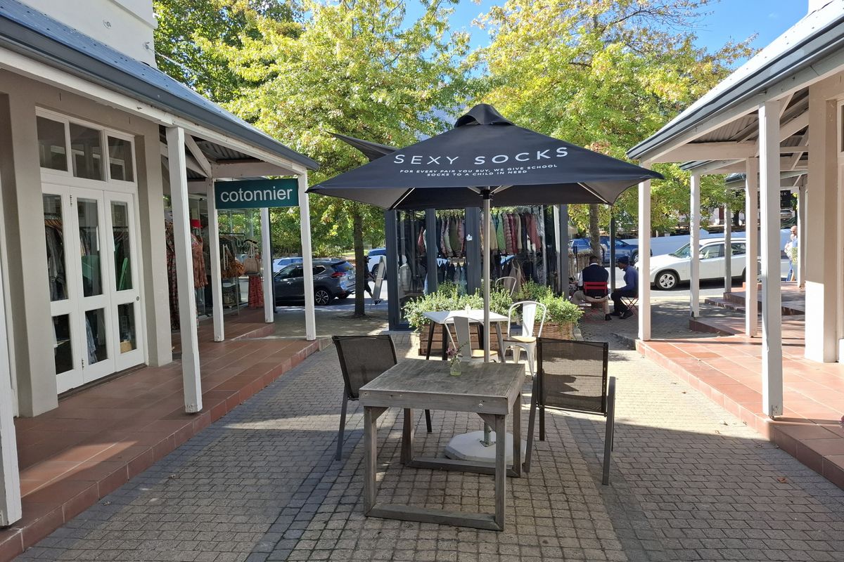 A paved outdoor courtyard area featuring covered walkways and tiled veranda sections, providing a pleasant communal space between building wings.