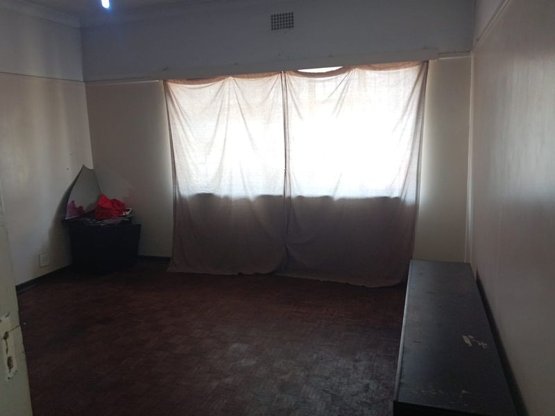 A vacant bedroom featuring parquet flooring and coved ceilings, offering a blank canvas for renovation and interior design updates.
