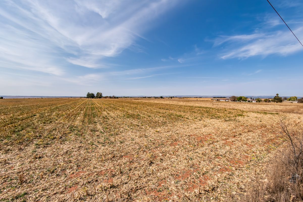 A wide-angle view of expansive, flat residential vacant land under a clear blue sky, suitable for development.