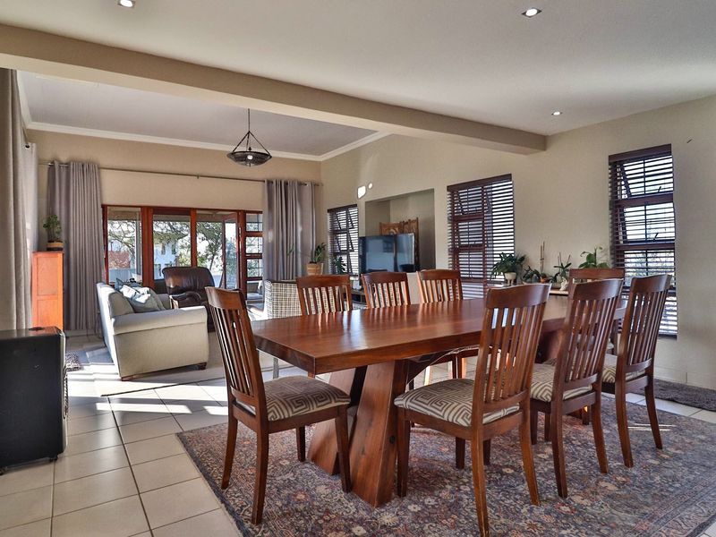 Spacious open-plan living and dining area featuring tiled floors, recessed lighting, and large sliding glass doors providing natural light and access to the outdoors.