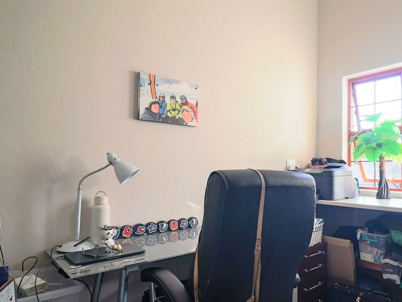 A functional home office space featuring a built-in desk area and a window providing natural light.