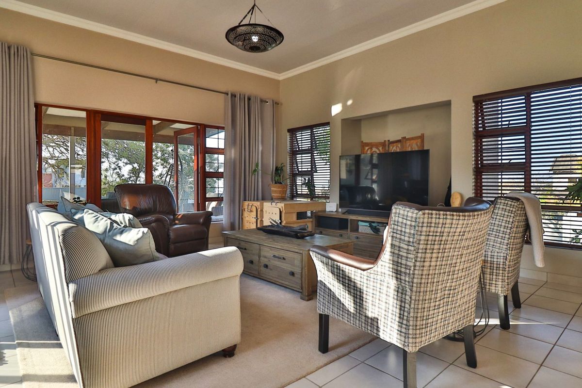 A comfortable living room featuring tiled floors, a recessed media wall, and large sliding glass doors that provide access to the outdoor area.