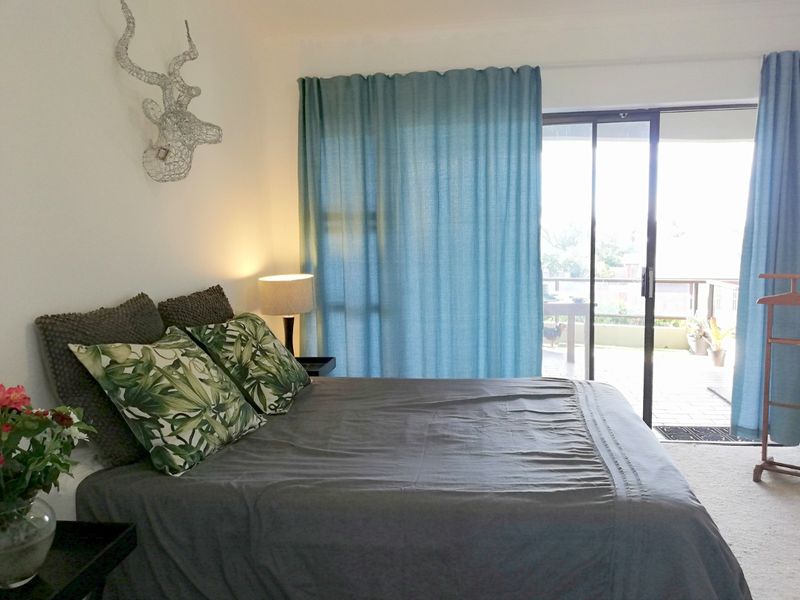 A bedroom featuring carpeted flooring and a sliding glass door providing direct access to an outdoor balcony area.