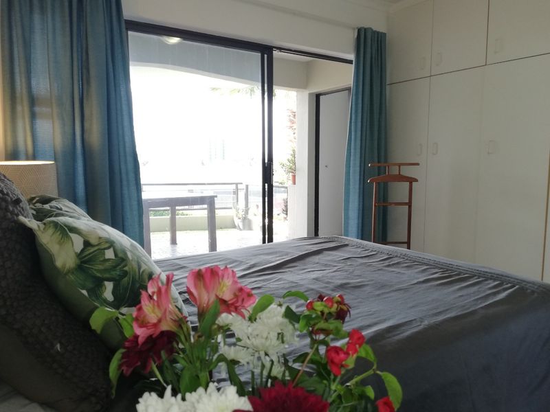 Bedroom featuring built-in cupboards and a sliding glass door providing direct access to a private balcony.