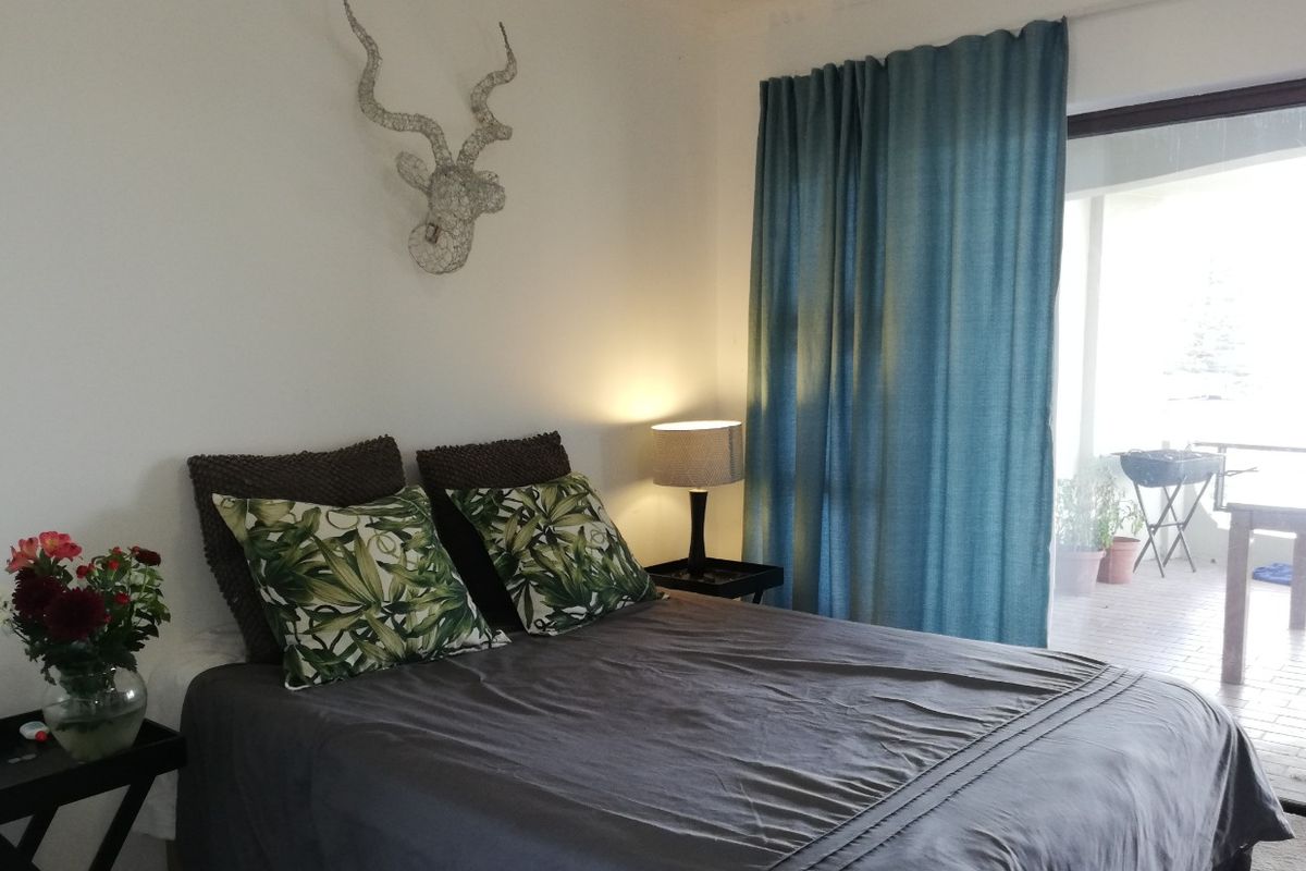 A comfortable bedroom featuring a sliding glass door that provides access to an outdoor patio area.