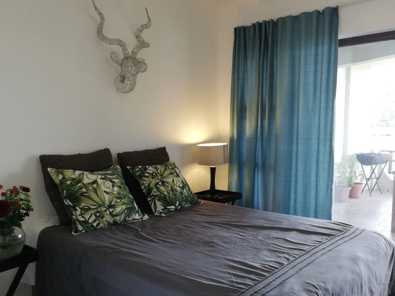 A comfortable bedroom featuring a sliding glass door that provides access to an outdoor patio area.