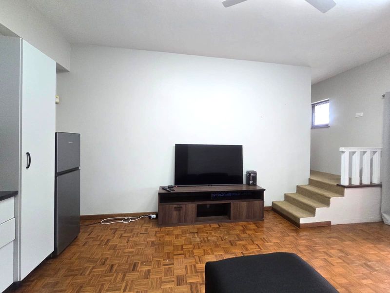 Living area featuring classic parquet flooring and an internal staircase with a white balustrade.