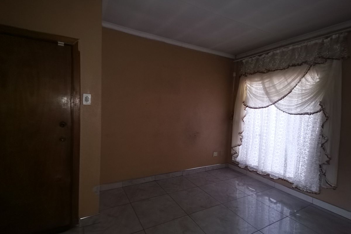 An empty bedroom featuring tiled flooring, coved ceilings, and neutral wall finishes, providing a blank canvas for personalization.