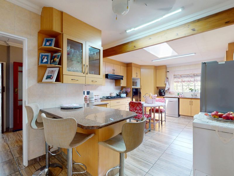 A functional kitchen featuring light wood cabinetry, granite countertops, a breakfast nook, and a skylight, providing a bright and practical workspace.