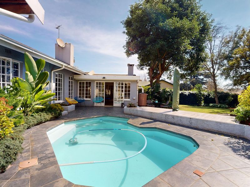 A well-maintained outdoor pool area featuring a paved patio, swimming pool, and direct access to the home through classic french doors.