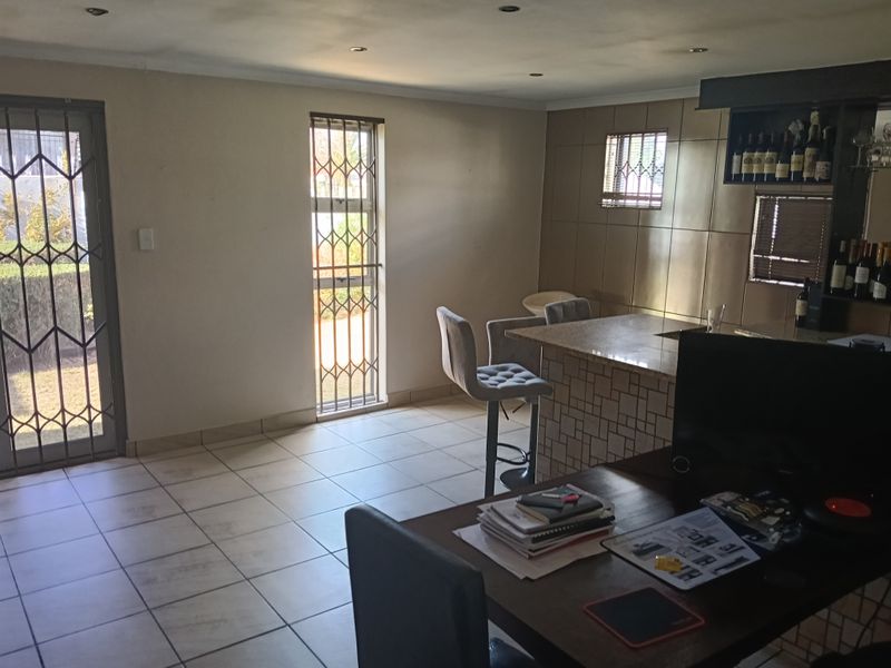 A functional bar area featuring a built-in counter, tiled wall finishes, and secure access points, providing a dedicated space for entertainment.