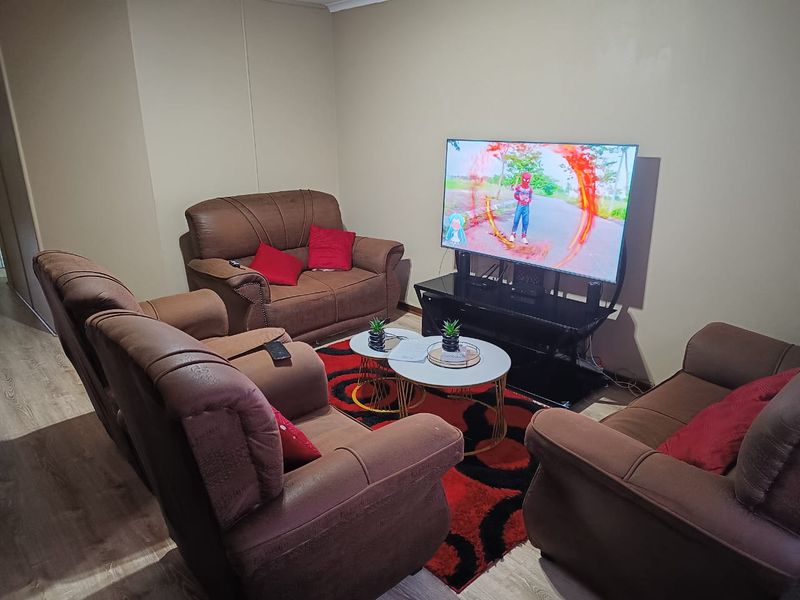 A comfortable living room featuring laminate flooring and neutral wall finishes, providing a functional space for relaxation and entertainment.