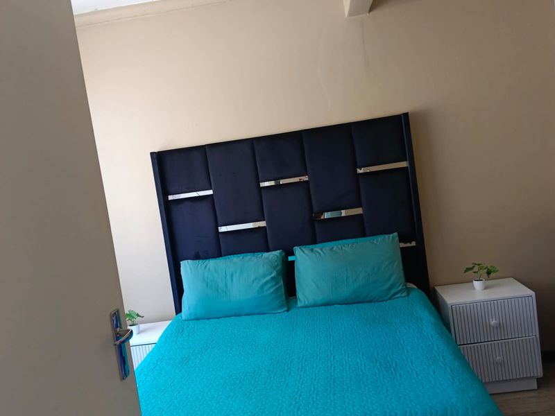 A bedroom featuring a neutral wall finish with visible signs of wear and cracking, requiring cosmetic attention.