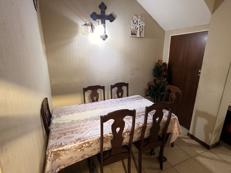 A dining area featuring tiled flooring and textured walls, providing a functional space for meals within the townhouse.