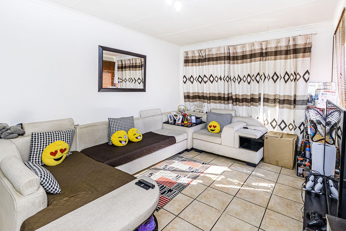A living room featuring tiled flooring and neutral wall finishes, providing a functional space for relaxation.