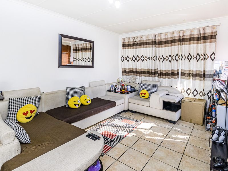 A living room featuring tiled flooring and neutral wall finishes, providing a functional space for relaxation.