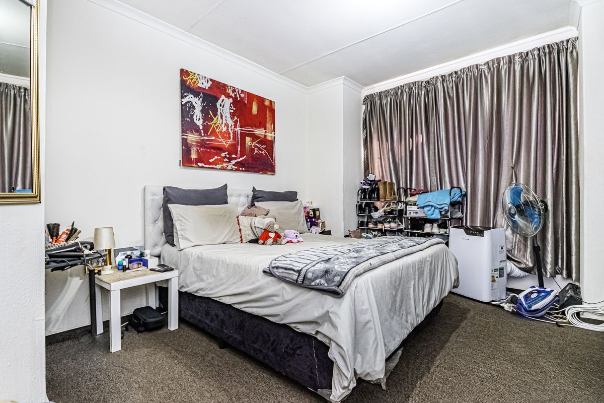 A standard bedroom featuring carpeted flooring and coved ceiling details, providing a functional space for rest.