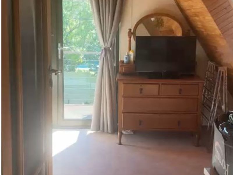 A bedroom featuring a distinctive timber-clad vaulted ceiling and direct access to an outdoor balcony area.