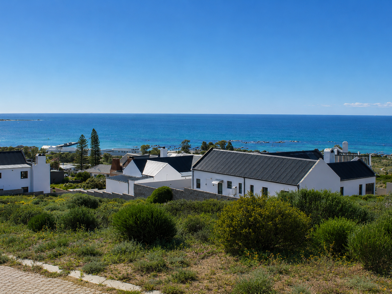 A scenic elevated view overlooking a coastal residential area with clear blue ocean horizons.