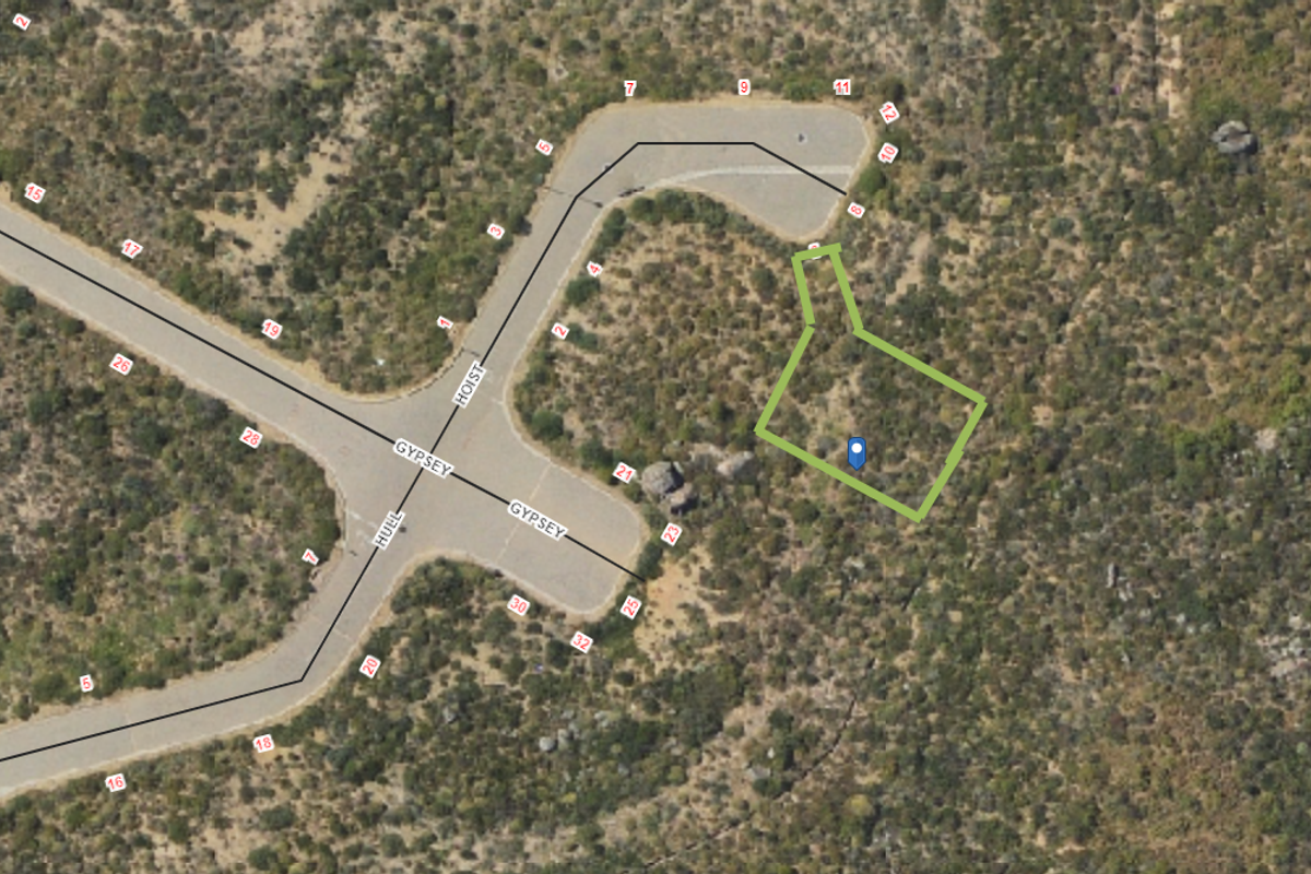 An aerial view showing the vacant residential land plot with boundary markings and adjacent street access.