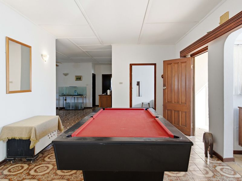 Spacious living area featuring traditional patterned floor tiles, wooden door frames, and an open-plan layout connecting to adjacent rooms.