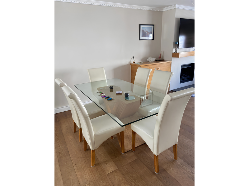 A well-maintained dining area featuring warm wooden flooring, crown molding, and a built-in fireplace, creating a comfortable and inviting space for meals.