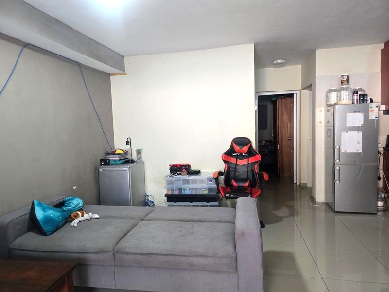 Open plan living area featuring tiled flooring and direct access to adjacent rooms, requiring cosmetic updates to wall finishes and general maintenance.