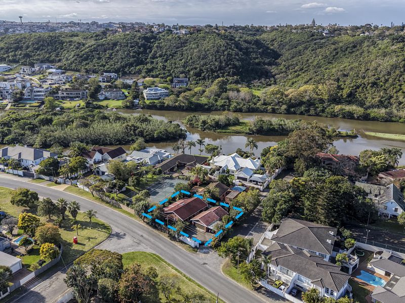 Aerial view of the property highlighting its location, roof structure, and surrounding residential neighborhood with river and greenbelt views.