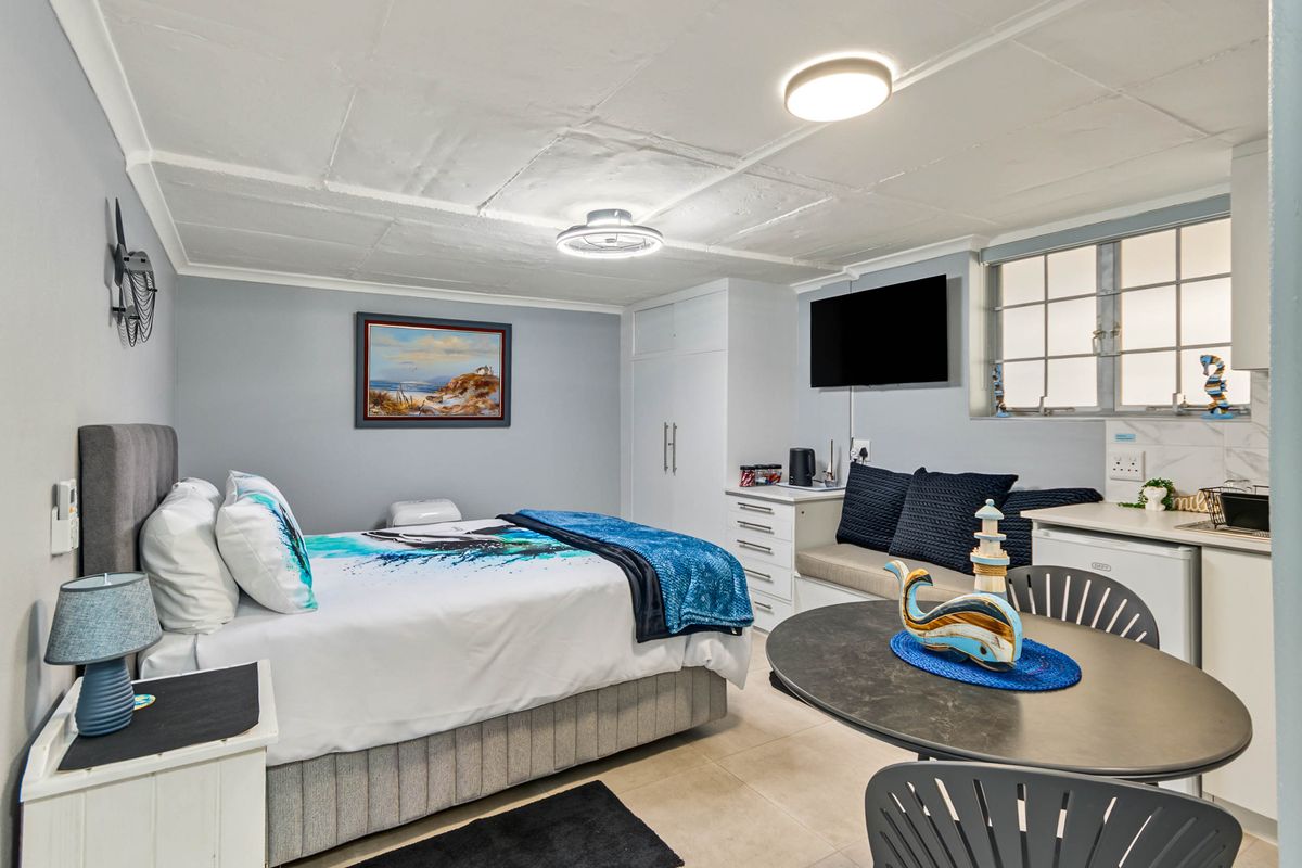 A well-maintained bedroom featuring built-in cupboards, tiled flooring, and functional ceiling lighting, offering a comfortable and practical living space.