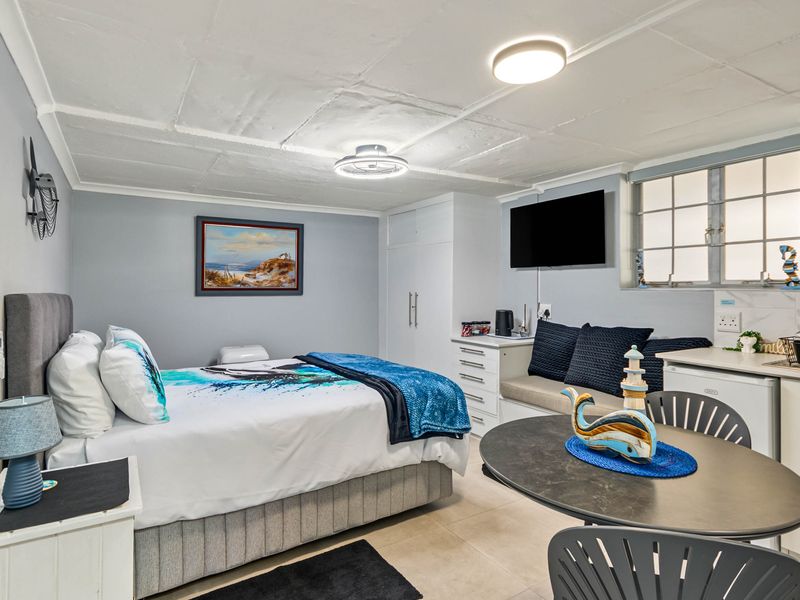 A well-maintained bedroom featuring built-in cupboards, tiled flooring, and functional ceiling lighting, offering a comfortable and practical living space.