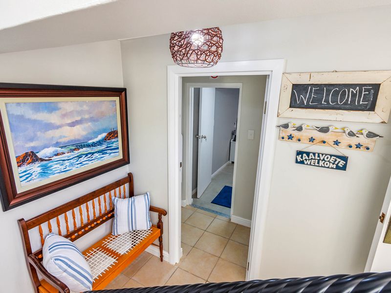 A bright hallway featuring tiled flooring and a clear transition into an adjacent room, finished with neutral wall tones.