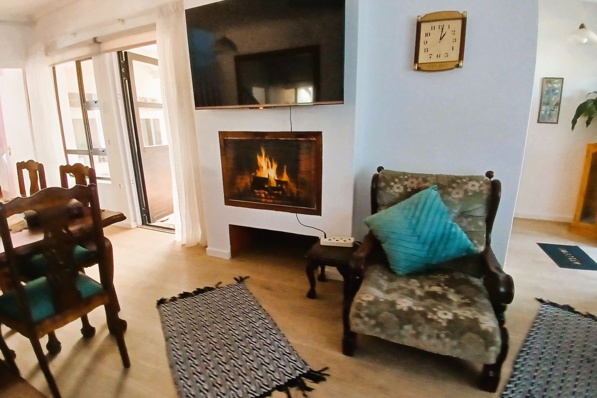 A cozy living room featuring a built-in fireplace, laminate flooring, and direct access to an outdoor area through sliding glass doors.