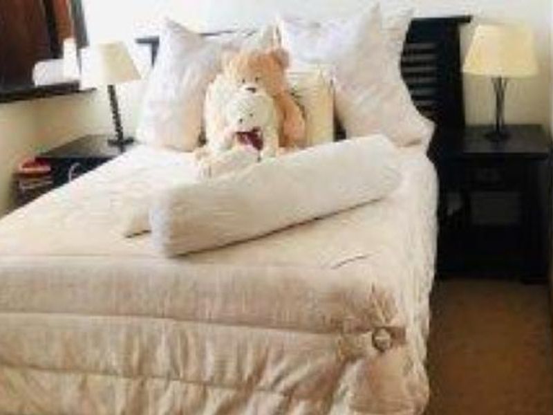 A bedroom featuring a bed with a headboard and bedside tables.