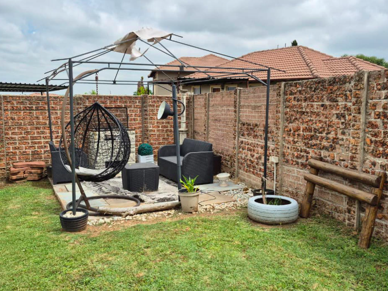 Outdoor patio area featuring a paved base and enclosed by a brick boundary wall, offering a private space for outdoor relaxation.