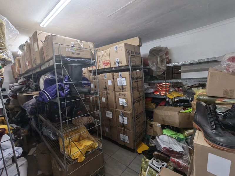 A utility storage room featuring industrial metal shelving units and fluorescent overhead lighting, currently utilized for bulk storage.
