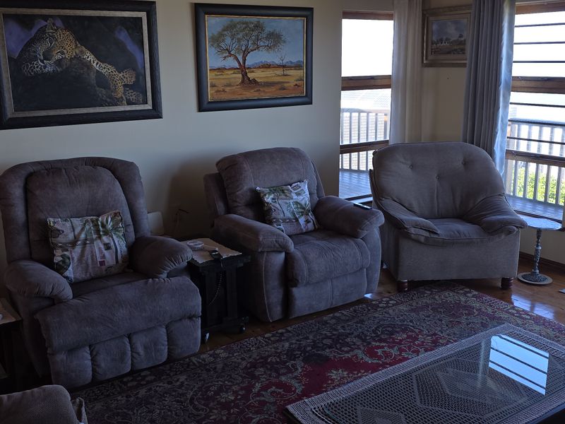 A comfortable living room featuring hardwood flooring and large sliding glass doors that provide access to an outdoor balcony with scenic views.