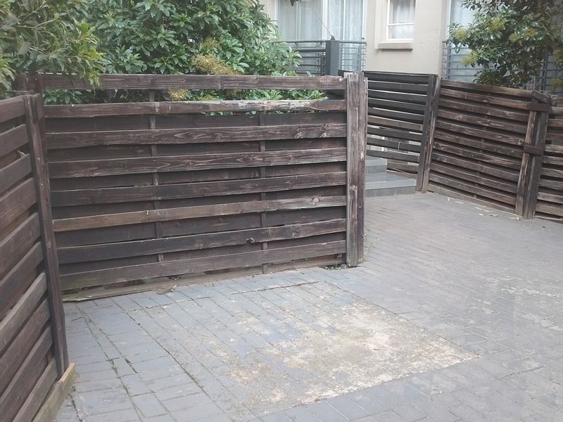 A private rear courtyard featuring timber slat fencing and paved flooring, offering a blank canvas for outdoor landscaping or patio development.