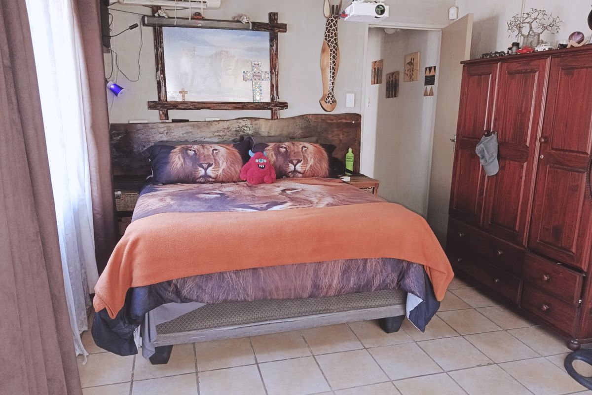 A bedroom featuring tiled flooring, a wall-mounted air conditioning unit, and a ceiling-mounted projector.