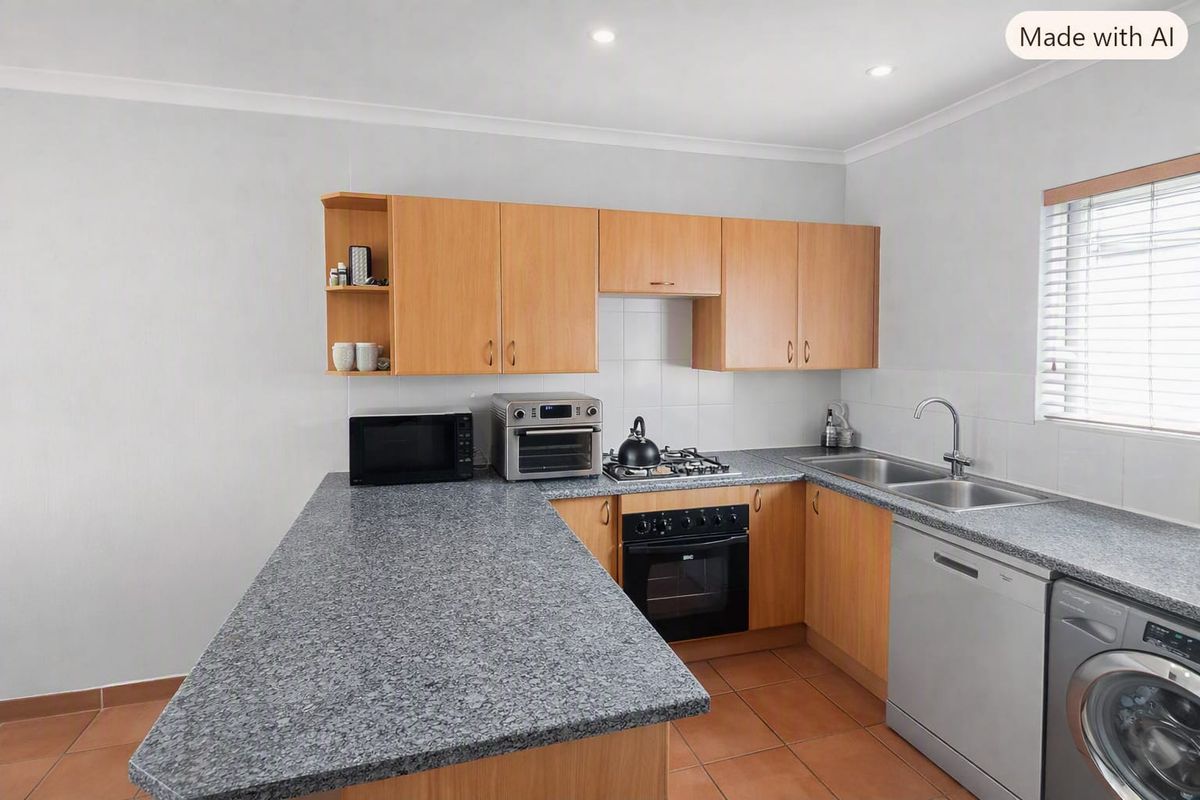 Functional kitchen featuring laminate cabinetry, granite-look countertops, built-in oven, gas hob, and tiled flooring with a breakfast bar extension.