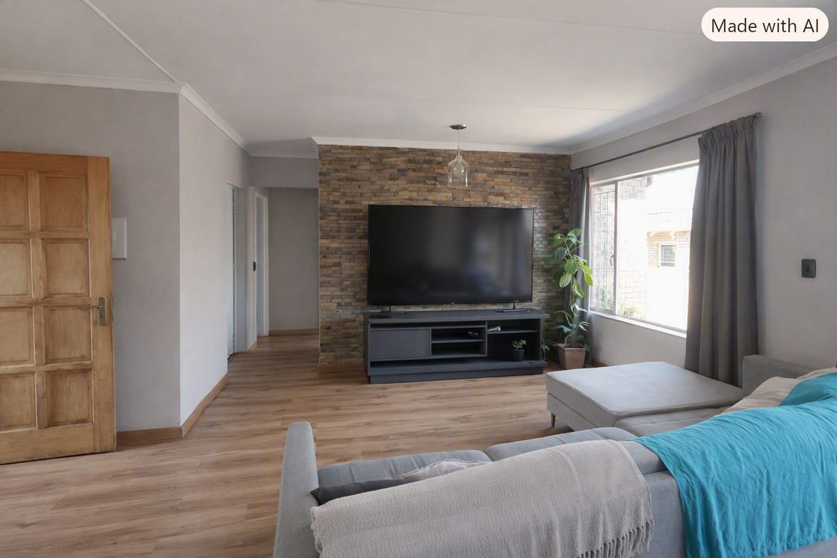 A well-maintained living room featuring a textured stone accent wall, modern laminate flooring, and natural light from a large window.