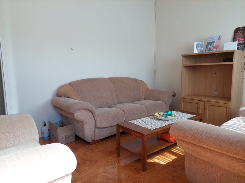 A living room area featuring tiled flooring and neutral wall finishes, providing a functional space for relaxation.